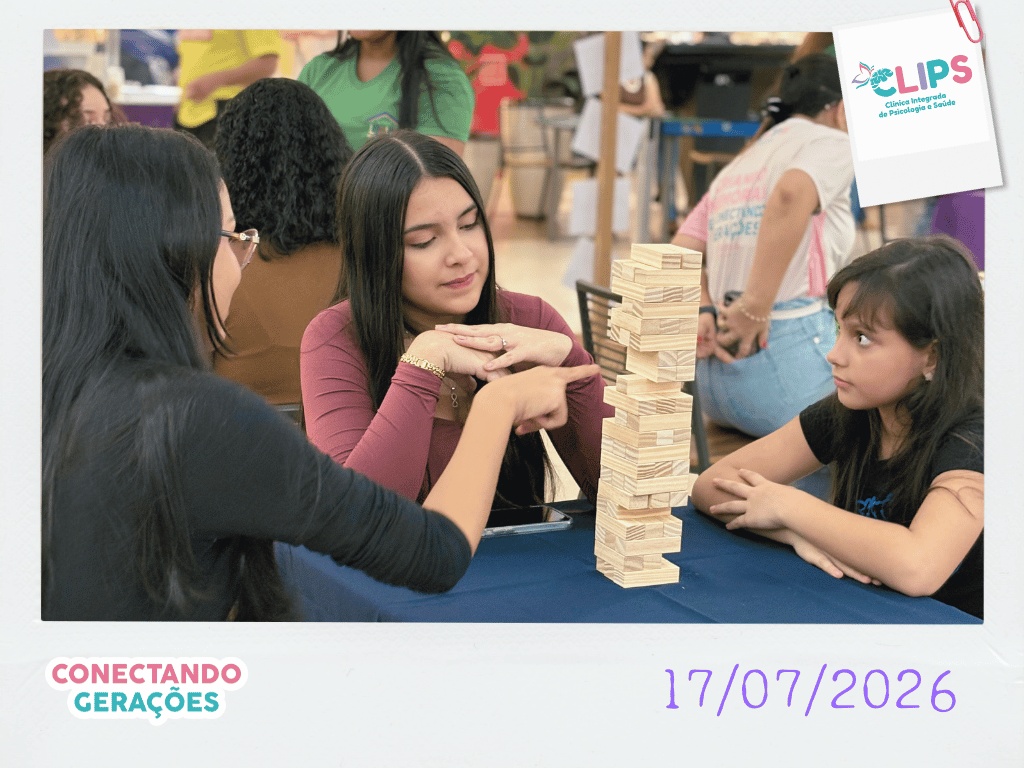 Jovens e criança jogando Jenga (torre de blocos de madeira) no evento Conectando Gerações da CLIPS em Santarém